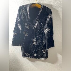 Women’s knit tunic with Asian flair. Black with all over ribbon decoration.